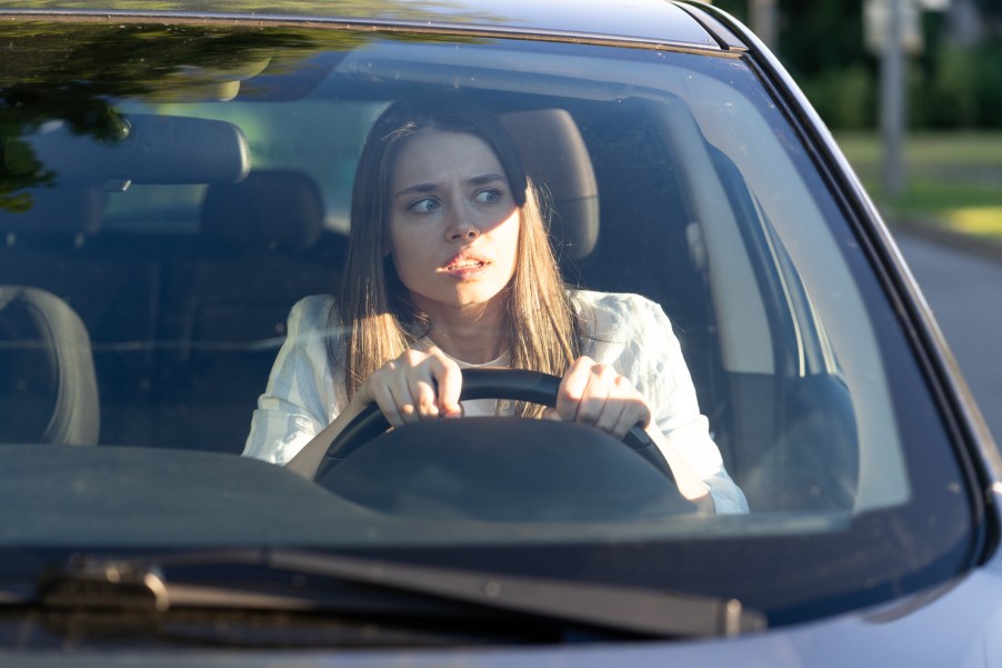 Female driver looks paranoid at what's next to the car