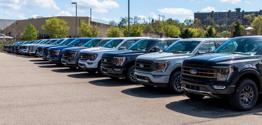 A row of F-150 trucks parked outside a Ford dealership