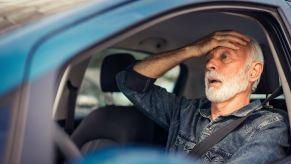 A male driver holding his right hand to his forehead depicting a false DUI