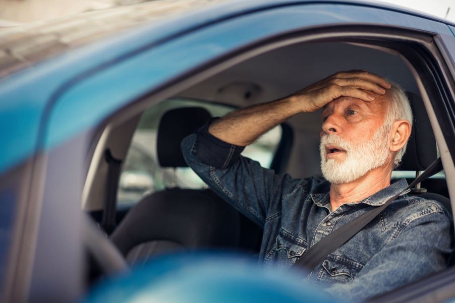 A male driver holding his right hand to his forehead depicting a false DUI