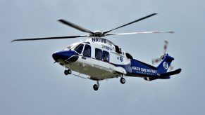 A blue and white medical helicopter in flight