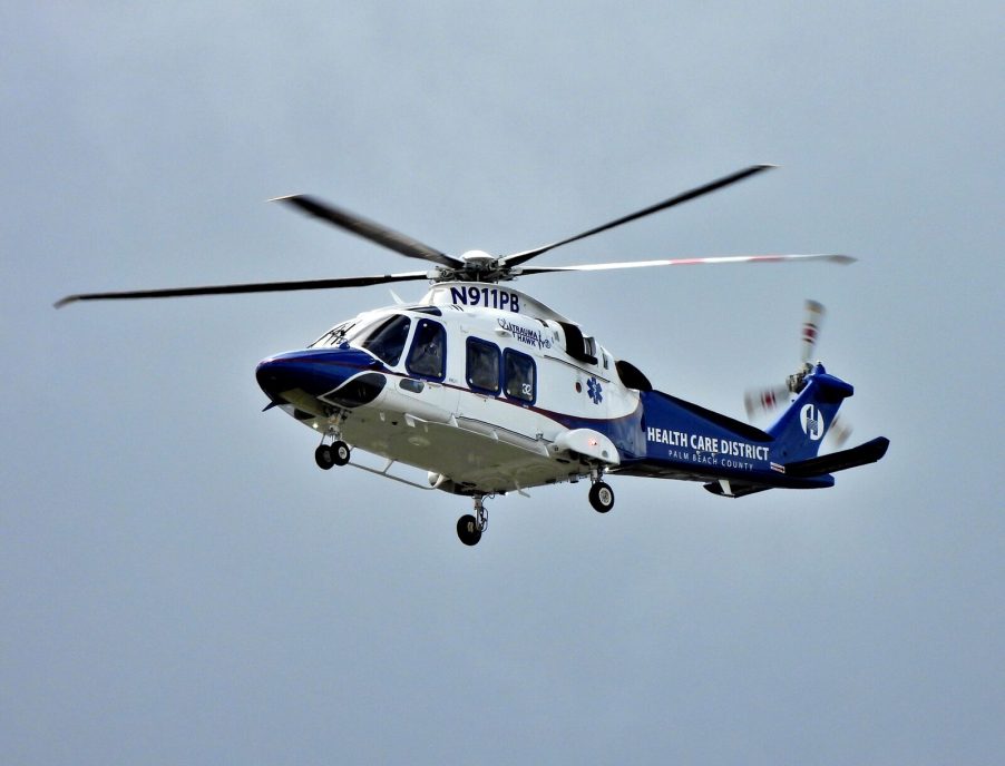 A blue and white medical helicopter in flight