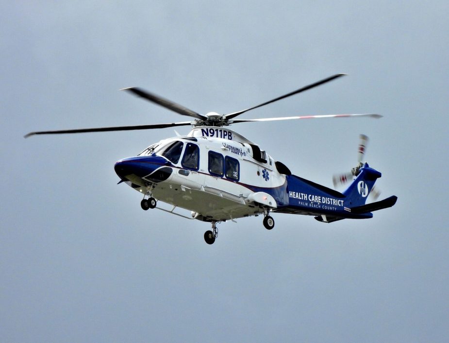 A blue and white medical helicopter in flight