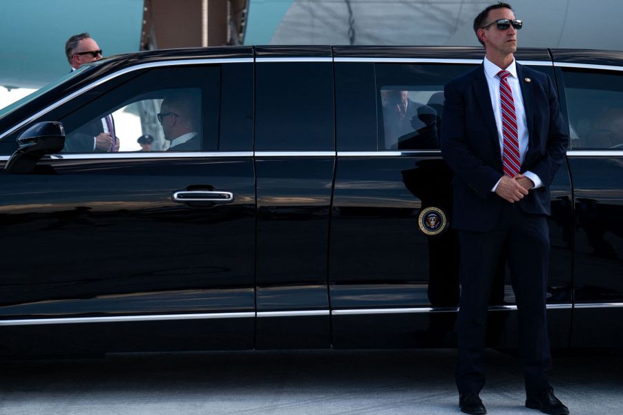 A Secret Service agent stands outside the presidential limousine
