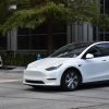 A white Tesla EV driving into an intersection in Texas