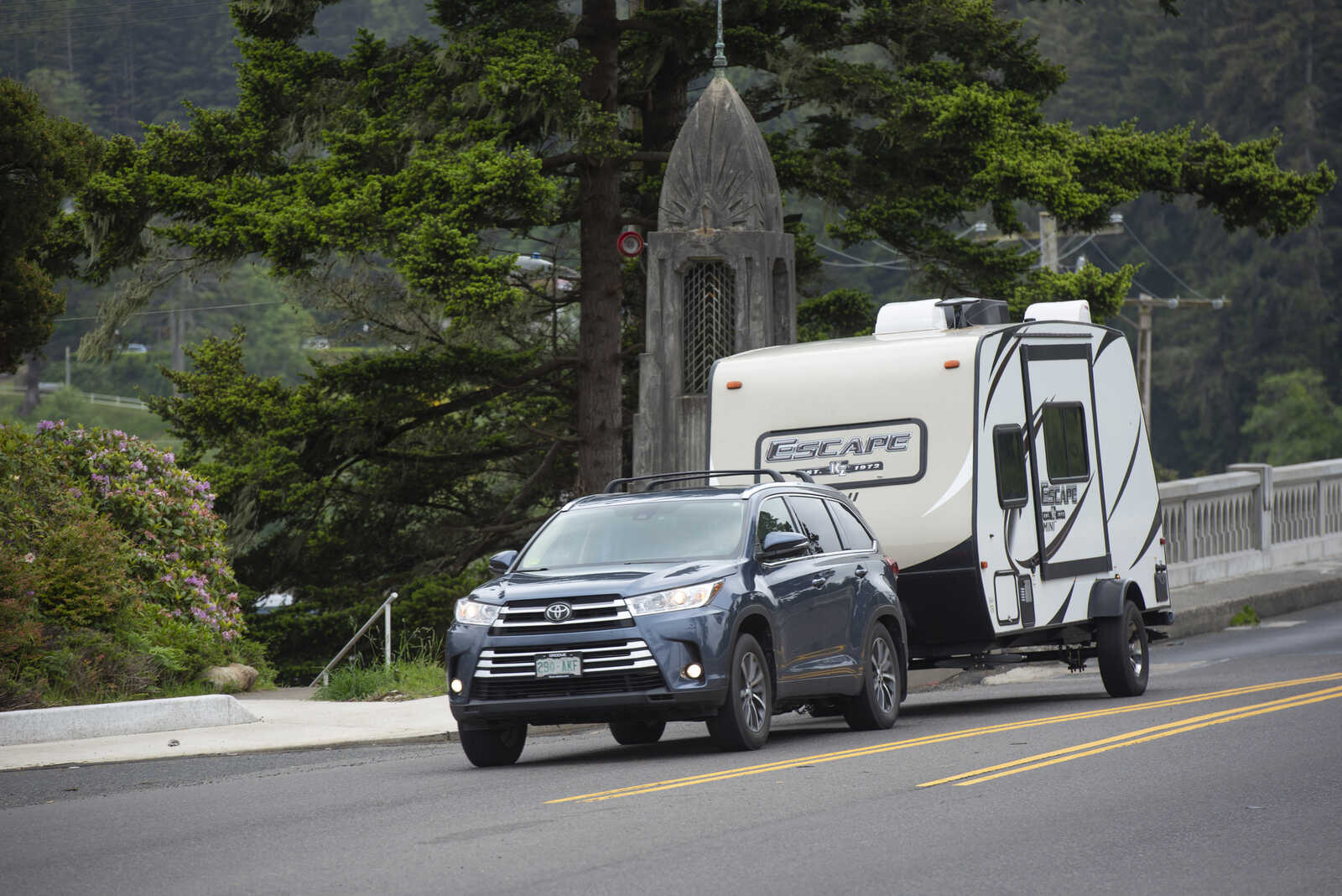 A light blue metallic Toyota RAV4 tows a camper