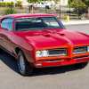 A red 1968 Pontiac GTO Hardtop Coupe 4-Speed parked in left front angle view