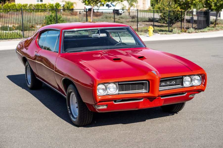 A red 1968 Pontiac GTO Hardtop Coupe 4-Speed parked in left front angle view