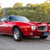 A red 1971 Pontiac Firebird Esprit 350 4-Speed parked outside in low right front angle view