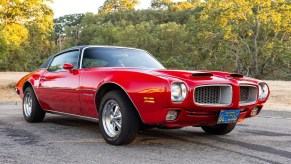 A red 1971 Pontiac Firebird Esprit 350 4-Speed parked outside in low right front angle view