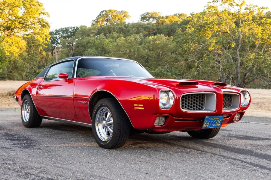 A red 1971 Pontiac Firebird Esprit 350 4-Speed parked outside in low right front angle view