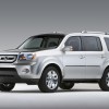 A silver 2009 Honda Pilot parked on a plain background in left front angle view