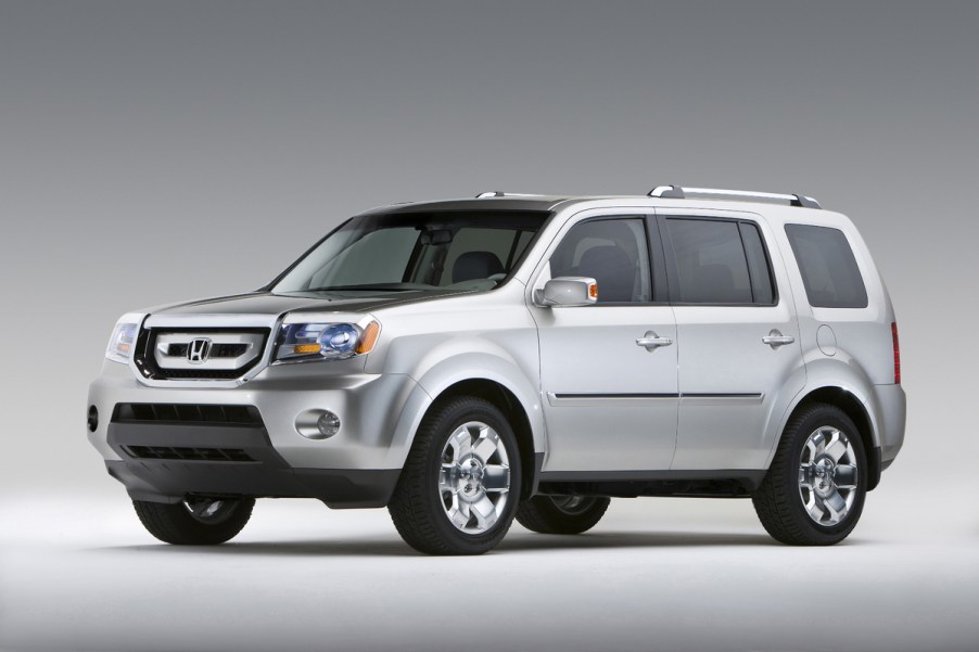 A silver 2009 Honda Pilot parked on a plain background in left front angle view