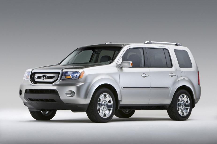 A silver 2009 Honda Pilot parked on a plain background in left front angle view