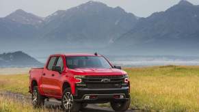 A red 2021 Chevrolet Silverado 1500 Trail Boss parked on a dirt road in right front angle view