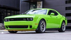 A neon green 2023 Dodge Challenger RT Scat Pack Widebody Swinger Edition 6-Speed parked in low left front angle view