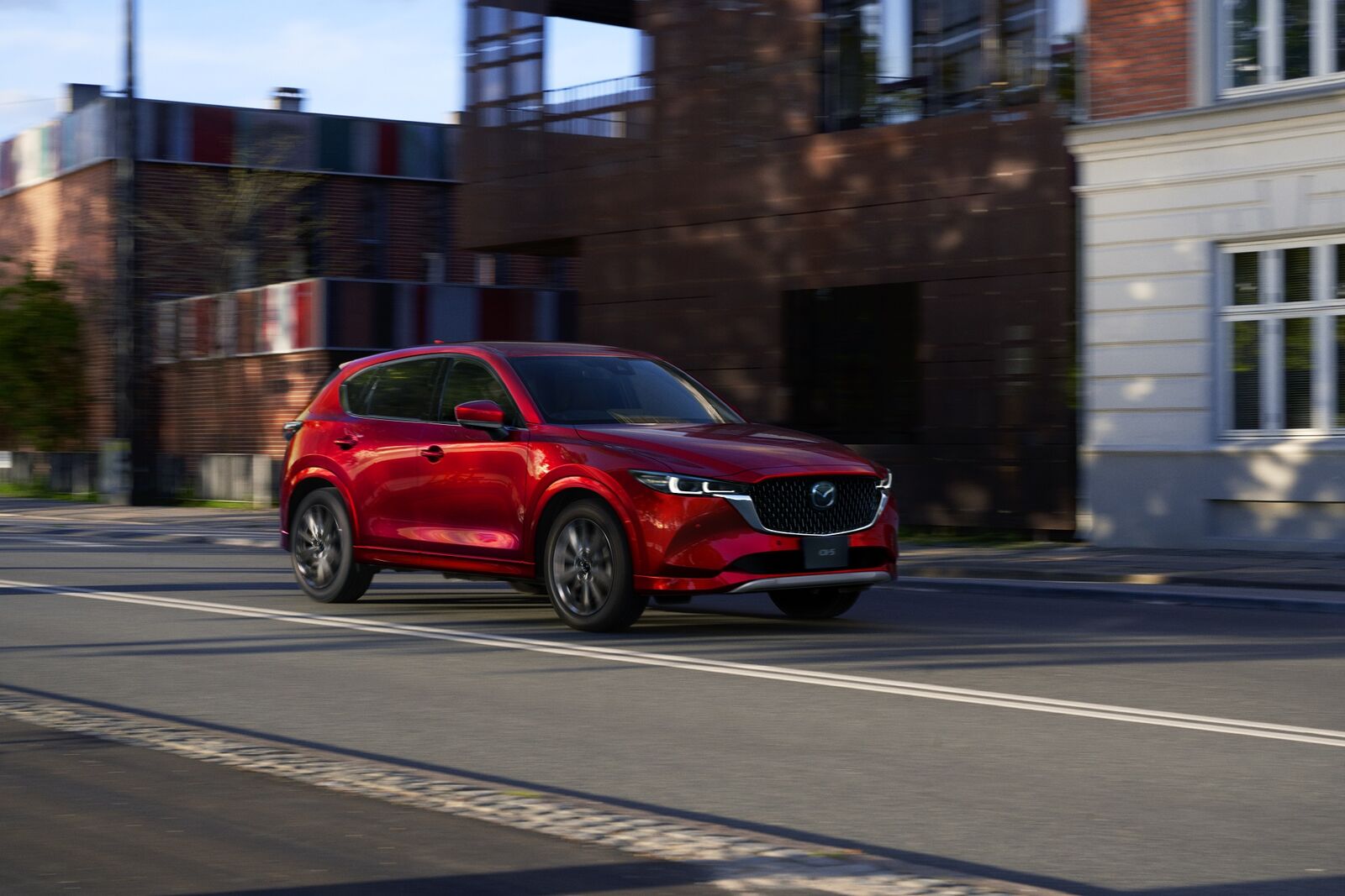 A red 2025 Mazda CX-5 driving in right front angle view