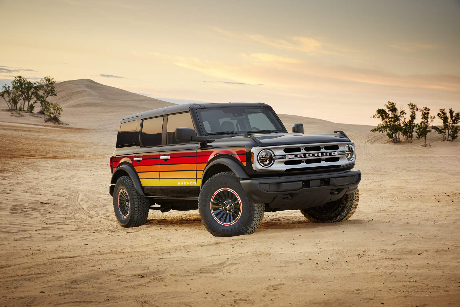 A black 2025 Ford Bronco with brightly colored striping parked off-road in a desert environment