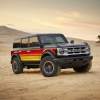 A black 2025 Ford Bronco with brightly colored striping parked off-road in a desert environment