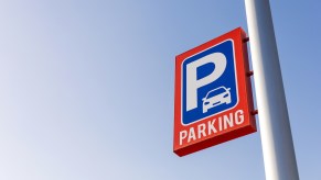 Parking sign on a pole above an airport lot.