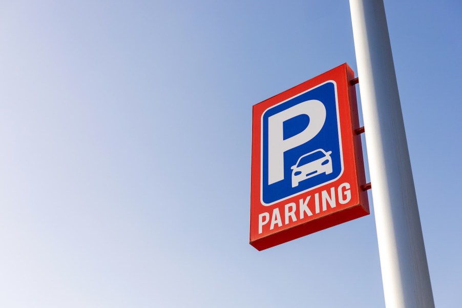 Parking sign on a pole above an airport lot.