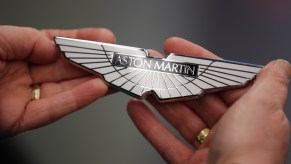 Technician holds white Aston Martin badge