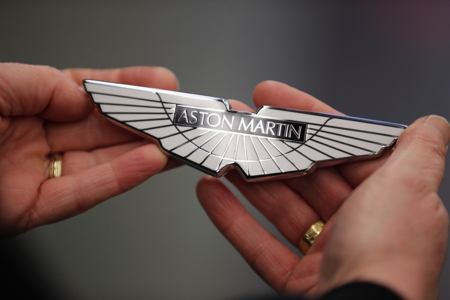 Technician holds white Aston Martin badge