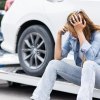 Woman sits on tow truck while her car gets repossessed.