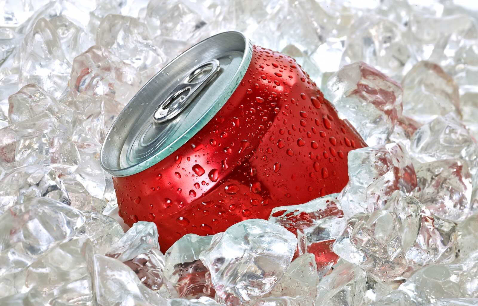 Red soda can floating in ice.