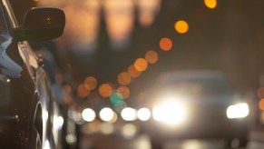 Row of cars with daytime running lights illuminated at dusk