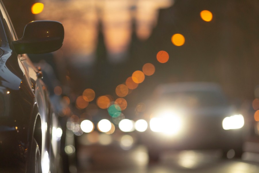 Row of cars with daytime running lights illuminated at dusk