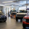 A Ford dealership showroom with a Maverick in the foreground and an F-150 pickup truck in the background.