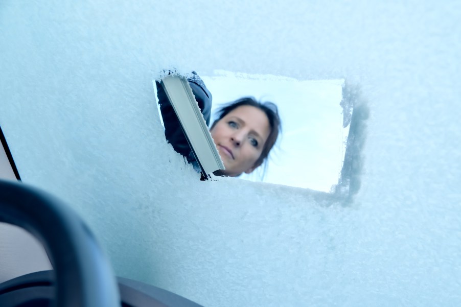 A woman defrosting a windshield