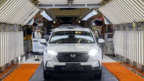 White Honda crossovers roll off assembly line at a factory.