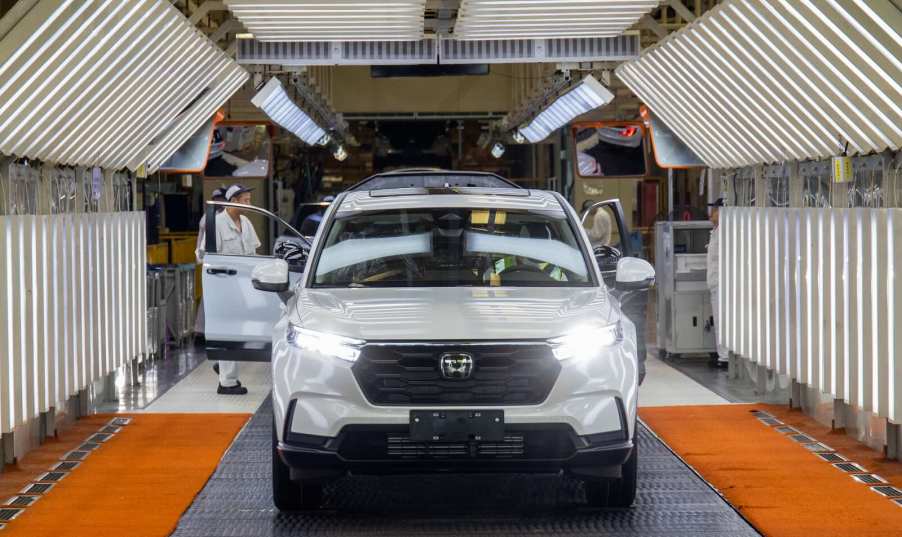 White Honda crossovers roll off assembly line at a factory.