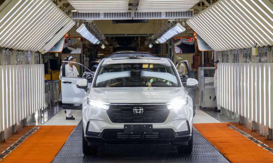White Honda crossovers roll off assembly line at a factory.