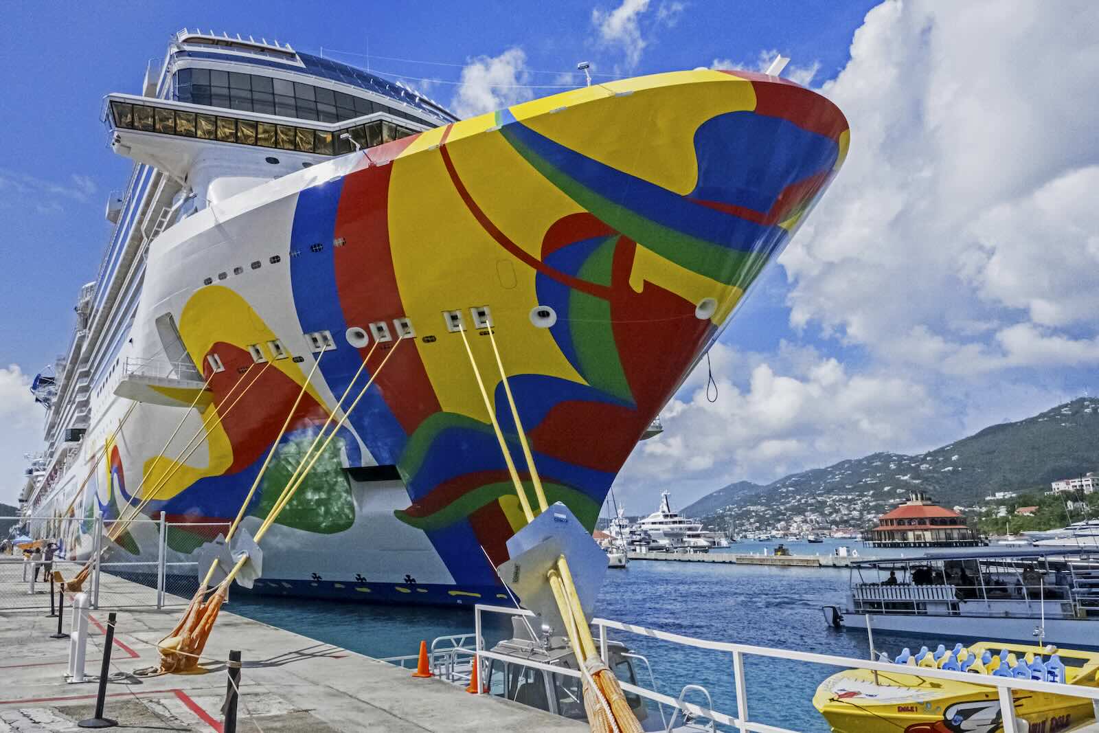 Cruise ship with a colorful paint job tied to a dock.