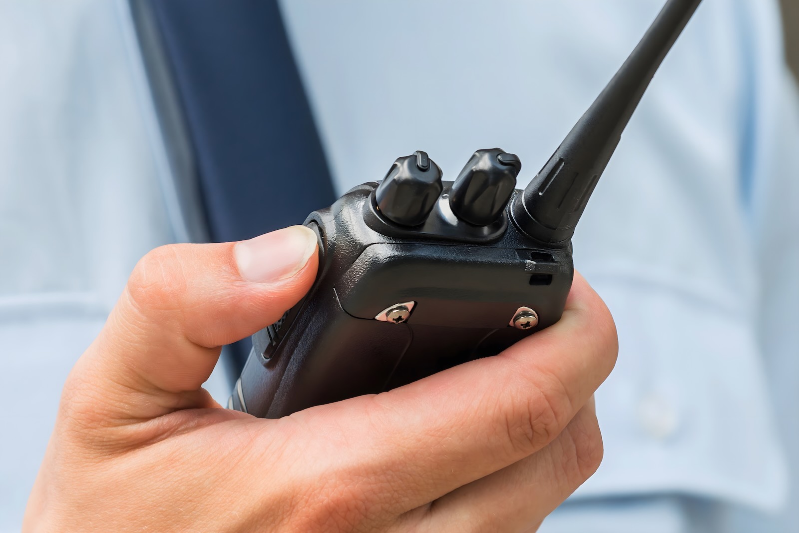 Police officer holds a radio while helping a woman deliver a baby
