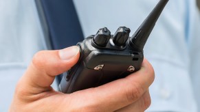 Police officer holds a radio while helping a woman deliver a baby