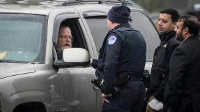 Three police offices talking to a Chevrolet Suburban driver during a traffic stop.