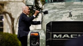 Joe Biden looks up at a Mack truck parked on the White House lawn