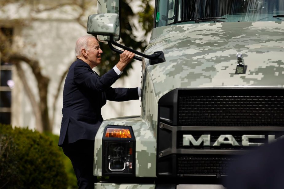 Joe Biden looks up at a Mack truck parked on the White House lawn