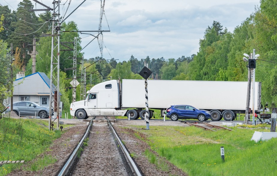 A semi-truck at a railroad crossing