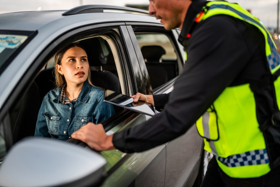 A police officer giving a woman a speeding ticket