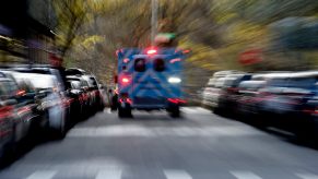Ambulance racing down a residential street and away into the distance.