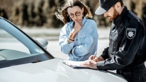 Police officer explains ticket to driver during traffic stop.