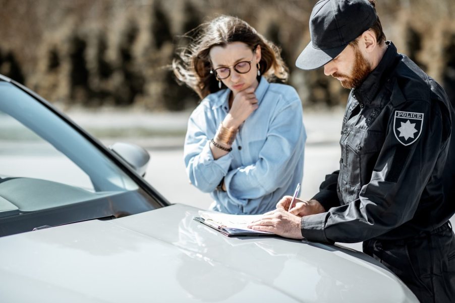 Police officer explains ticket to driver during traffic stop.