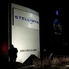 Workers unveil the new Stellantis sign at the company's Michigan headquarters.