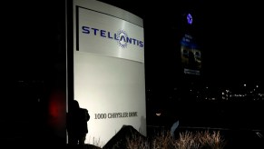 Workers unveil the new Stellantis sign at the company's Michigan headquarters.