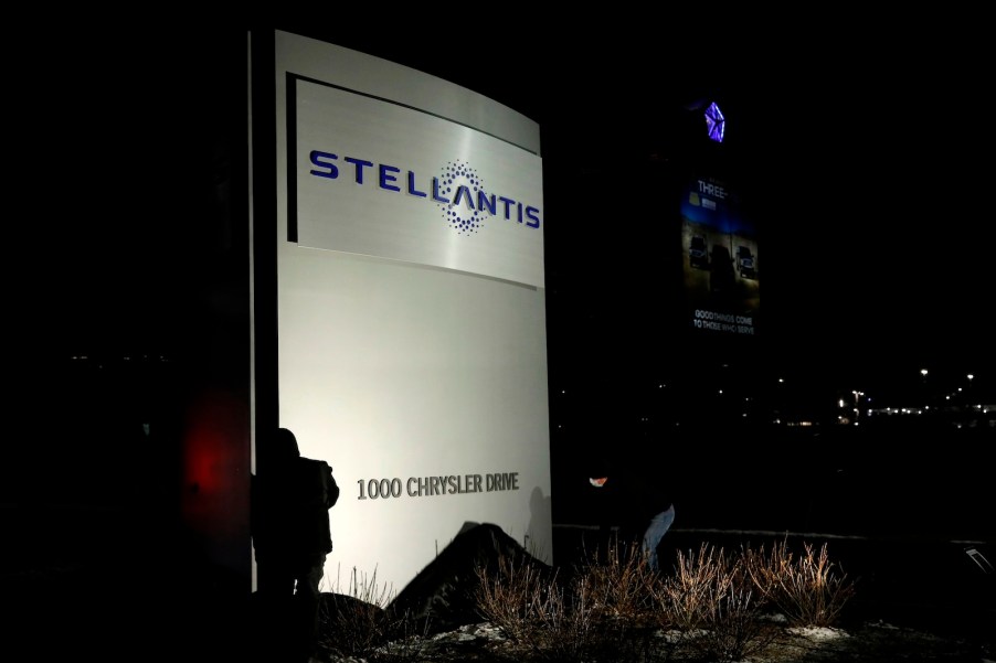 Workers unveil the new Stellantis sign at the company's Michigan headquarters.